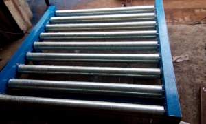 Gravity Conveyor System Installed In An Industrial Setting Showing Rollers Angled For Gravity Feed