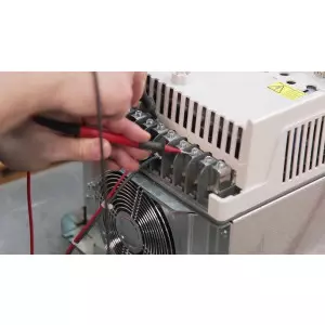 Technician Repairing An Industrial AC Drive Unit With Diagnostic Tools
