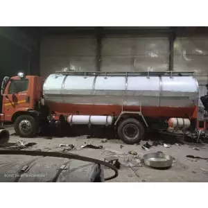 Stainless Steel Milk Storage Tanker Parked Outside A Dairy Farm