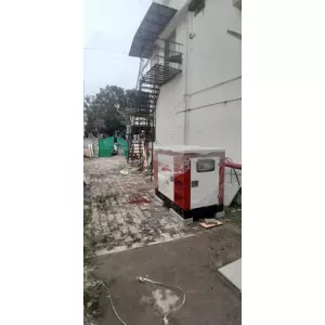 15 KVA Silent Diesel Generator Set Installed Outdoors Near An Industrial Building