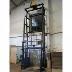 Hydraulic Goods Lift Operating Inside An Industrial Warehouse With Steel Frame And Control Panel