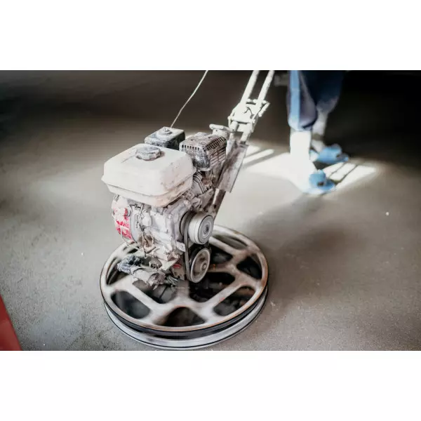 Worker Applying Concrete Floor Densification Coating In An Industrial Facility
