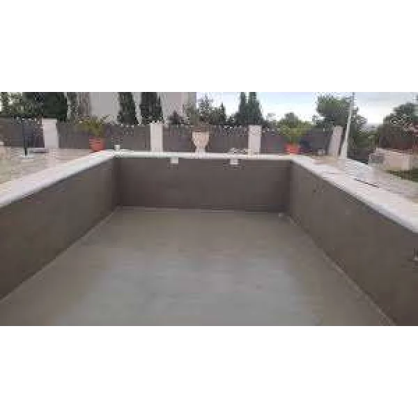 Worker Applying Waterproof Coating On Swimming Pool Surface